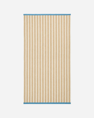 Full view of the rectangular blanket laid flat, with horizontal stripes on one half, vertical stripes on the other, and cream fringe at both ends.