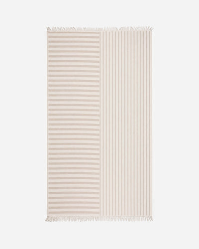 Full view of the rectangular blanket laid flat, with horizontal stripes on one half, vertical stripes on the other, and cream fringe at both ends.