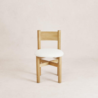 A straight back dining chair with white oak wooden legs and a white boucle upholstered seat. Teddy Dining Chair - White Oak