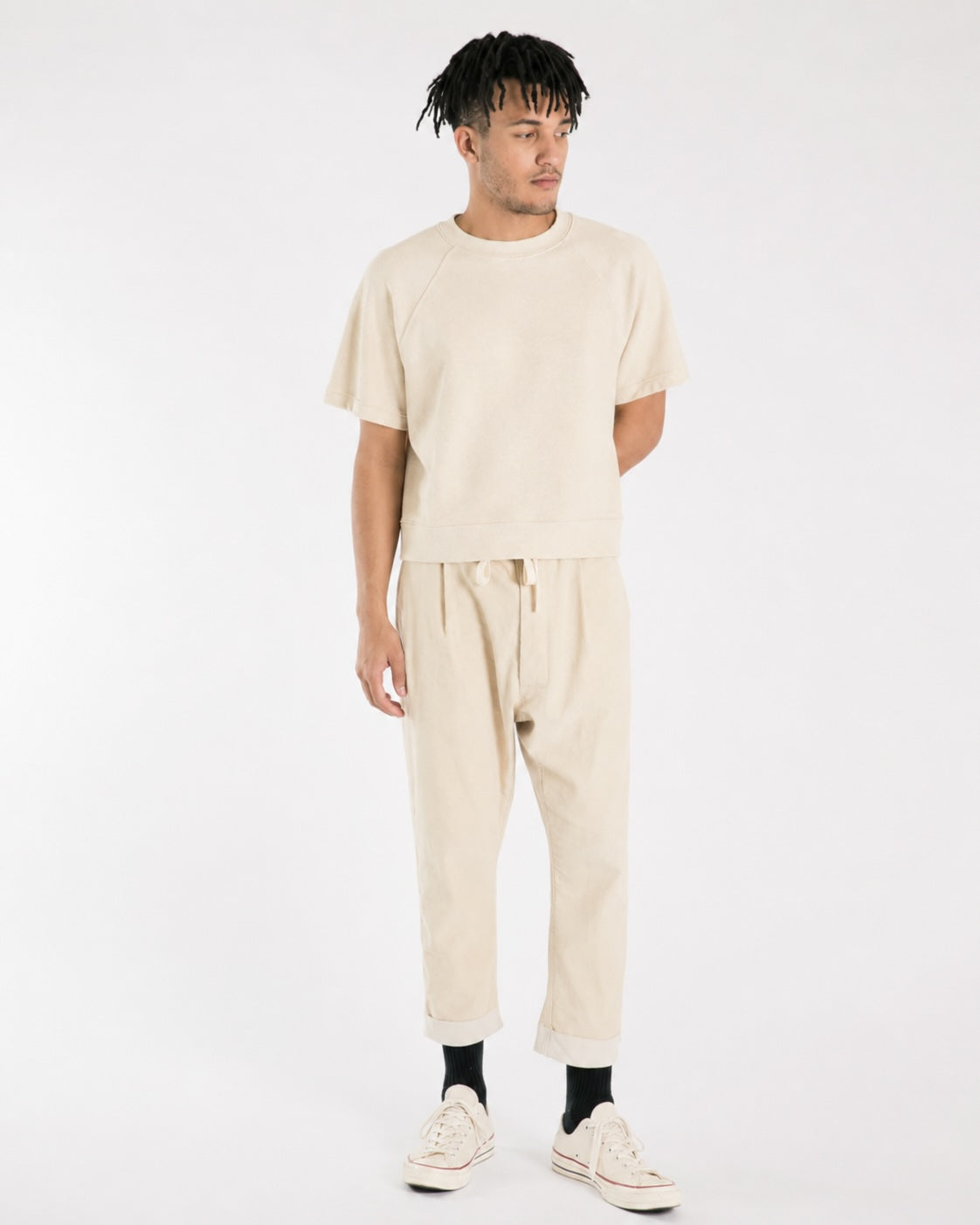 Model wearing cream corduroy Paddington pants with a matching T-shirt and white sneakers.