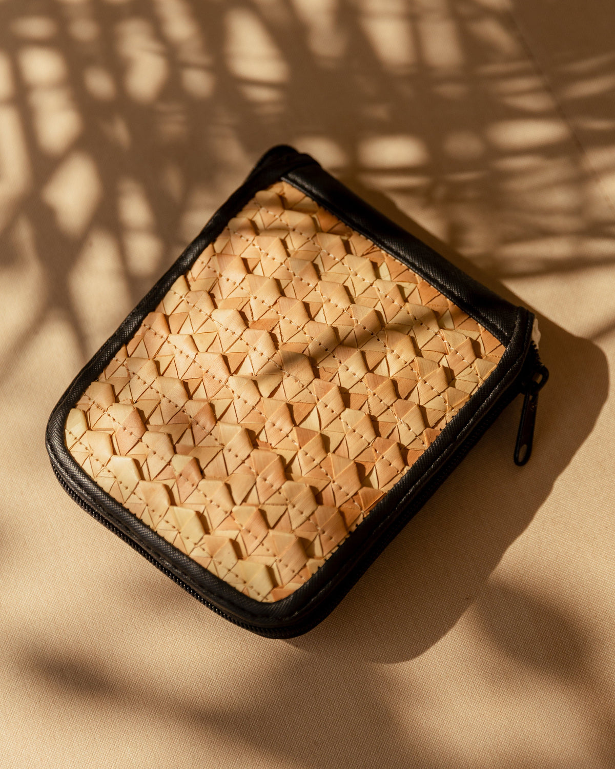 Village Thrive Rattan & Canvas Compact Eco Tote Bag, natural rattan cane with black trim, close-up angled view.