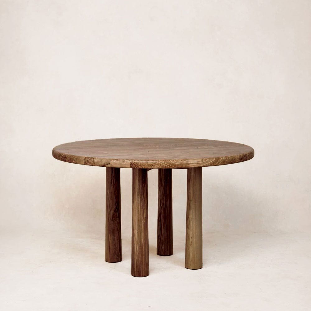 A round Topa Topa dining table made of solid White Oak wood with a warm natural stain finish, displayed against a neutral background.